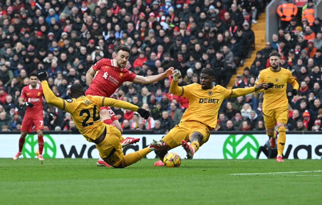 Wolves defender Emmanuel Agbadou slide tackles against Liverpool