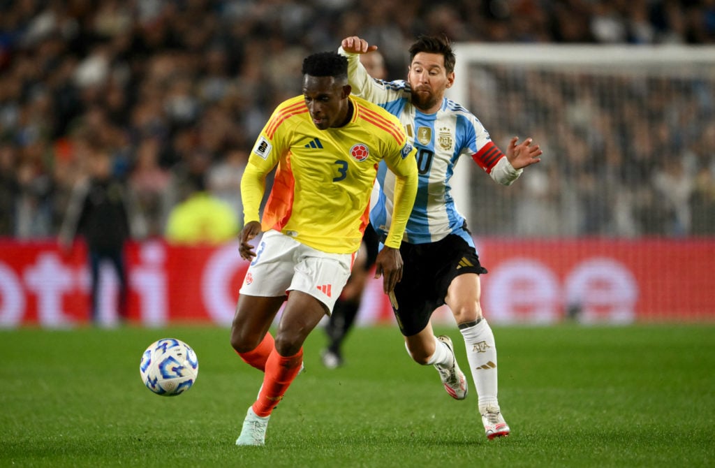 Colombia's Jhon Lucumi duels with Argentina's Lionel Messi