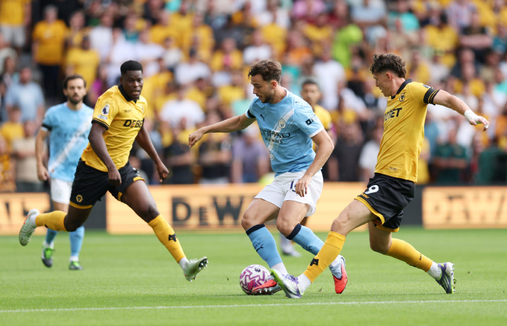 Nico Gonzalez of Manchester City is put under pressure by Jorgen Strand Larsen of Wolverhampton Wanderers