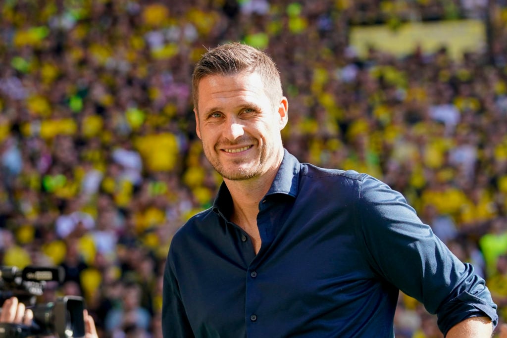 Borussia Dortmund sporting director Sebastian Kehl smiles.