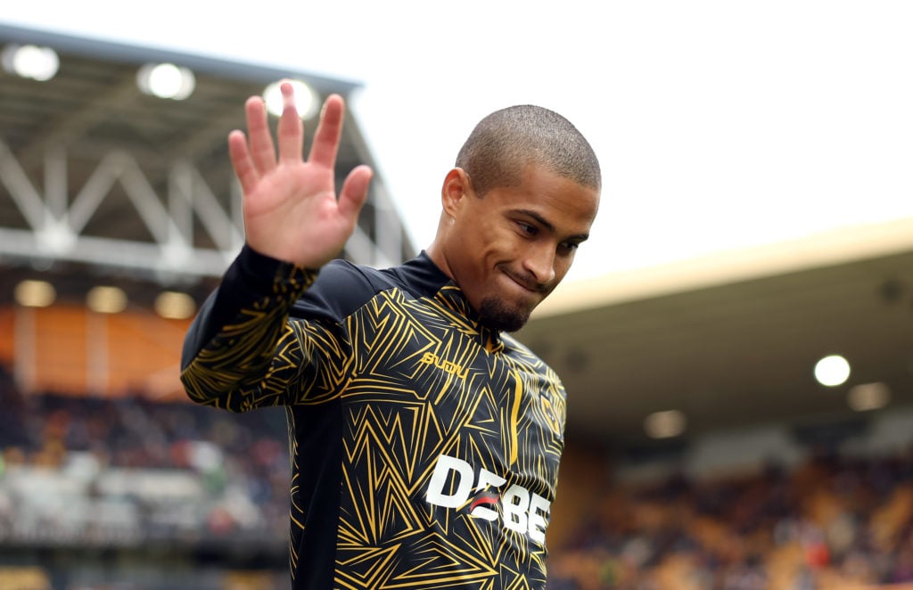 Wolves midfielder Joao Gomes waves to fans while warming up.