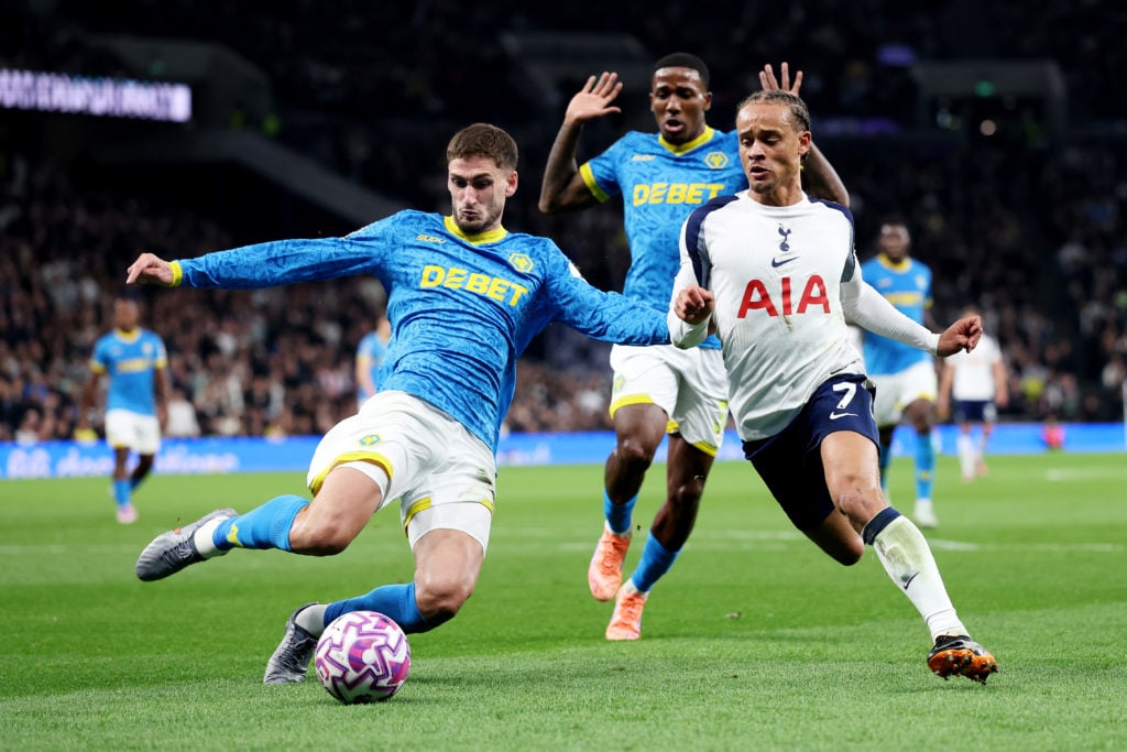 Santiago Bueno slides in on Xavi Simons while playing for Wolves.