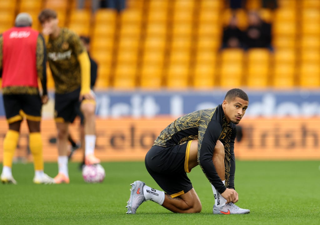 Joao Gomes ties his lace while warming up for Wolves.