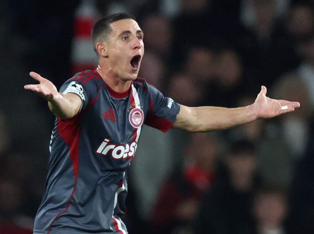 Olympiacos star Daniel Podence stretches out his arms.