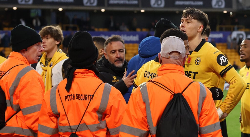 Vitor Pereira and Wolves players held back by stewards at Molineux.