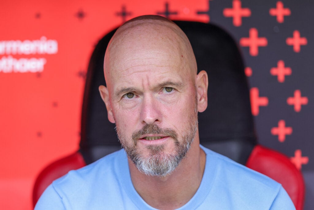Erik ten Hag looks on from the dugout while managing Bayer Leverkusen.