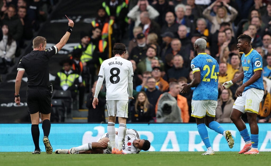 eferee John Brooks shows a red card to Emmanuel Agbadou of Wolverhampton Wanderers during the Premier League match between Fulham and Wolverhampton Wanderers