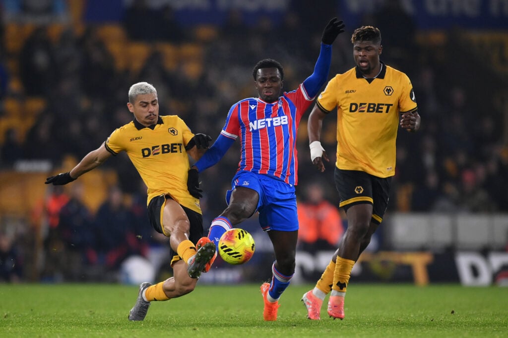 Eddie Nketiah of Crystal Palace is challenged by Joao Gomes of Wolverhampton Wanderers as Emmanuel Agbadou watches on