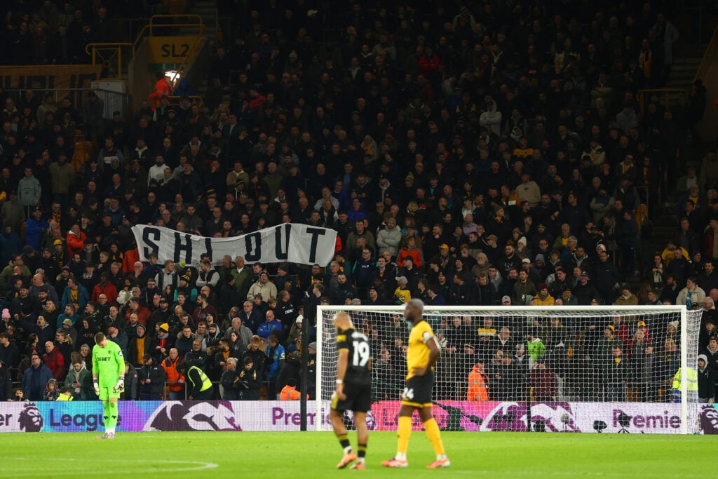Wolves fans hold aloft a 'Shi Out' banner at Molineux.