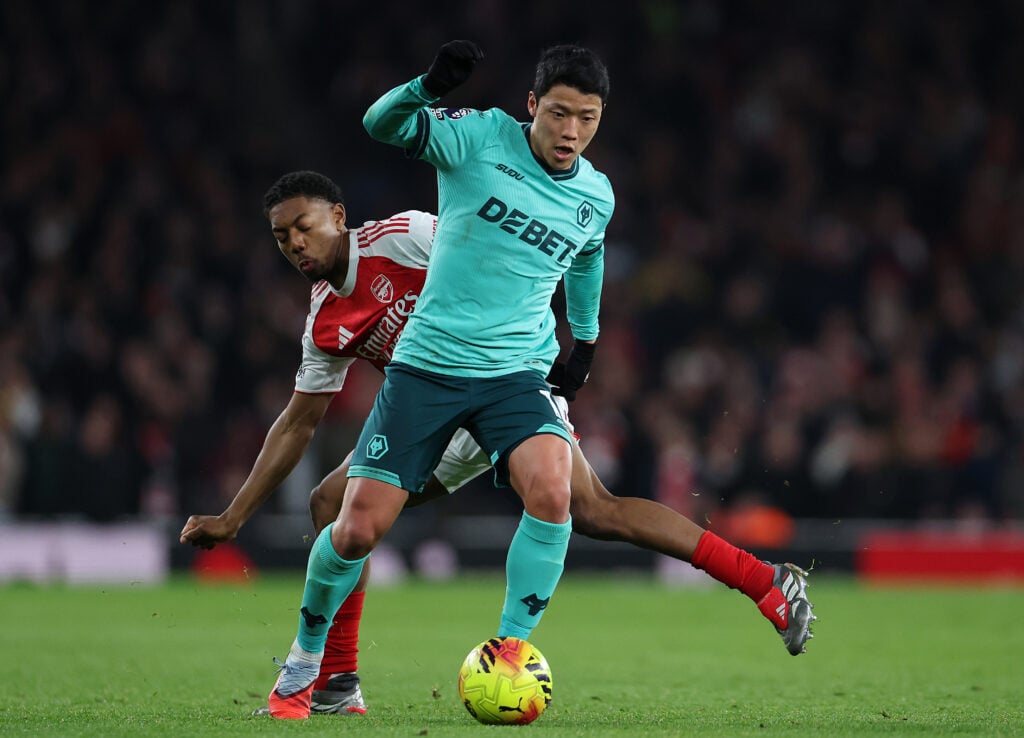 Hwang Hee-chan carrying the ball for Wolves under pressure from Myles Lewis-Skelly