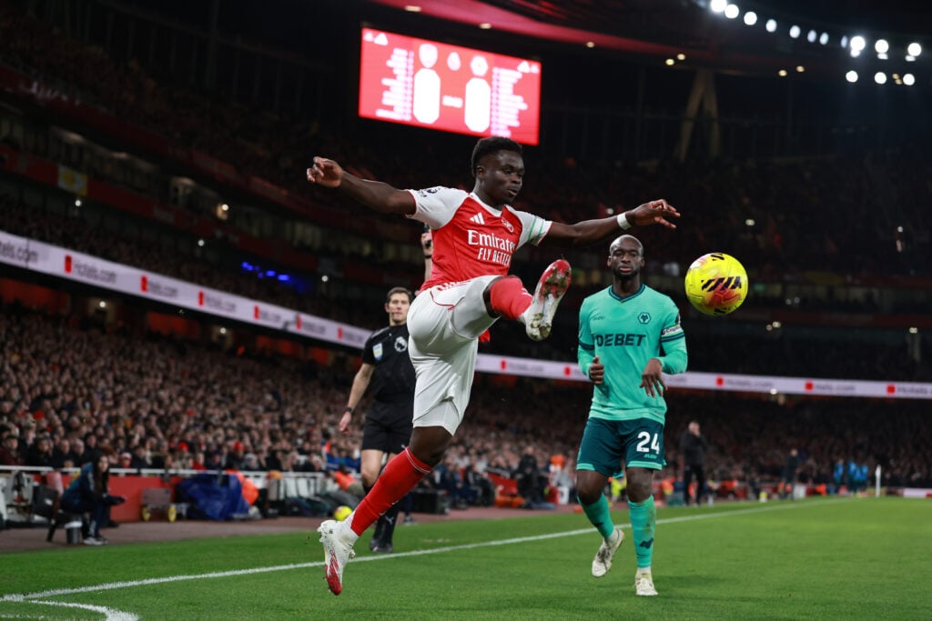Bukayo Saka brings the ball down for Arsenal.