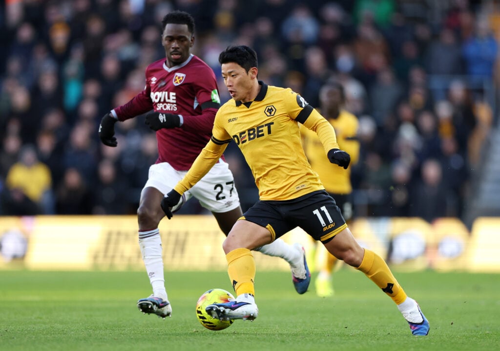Hwang Hee-Chan of Wolverhampton Wanderers runs with the ball whilst under pressure from Soungoutou Magassa of West Ham United