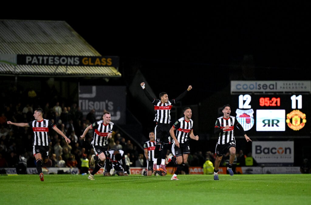 Grimsby players celebrate after beating Manchester United on penalties.