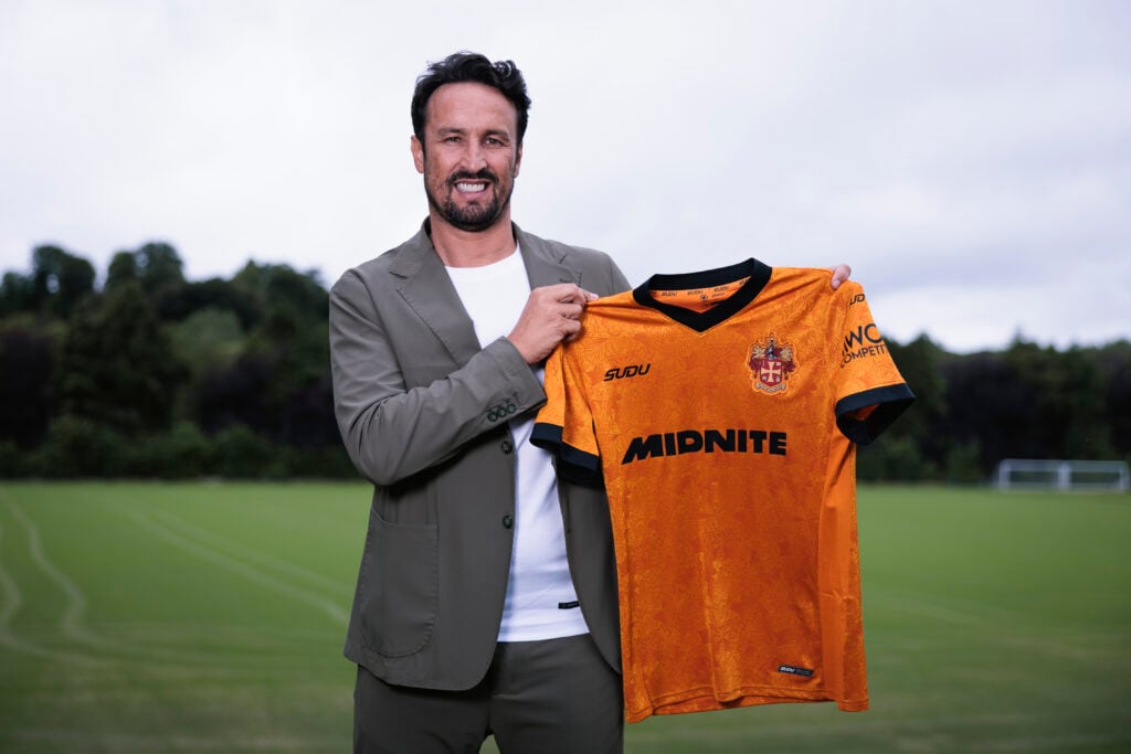 Cesar Peixoto holds up a Wolves shirt.